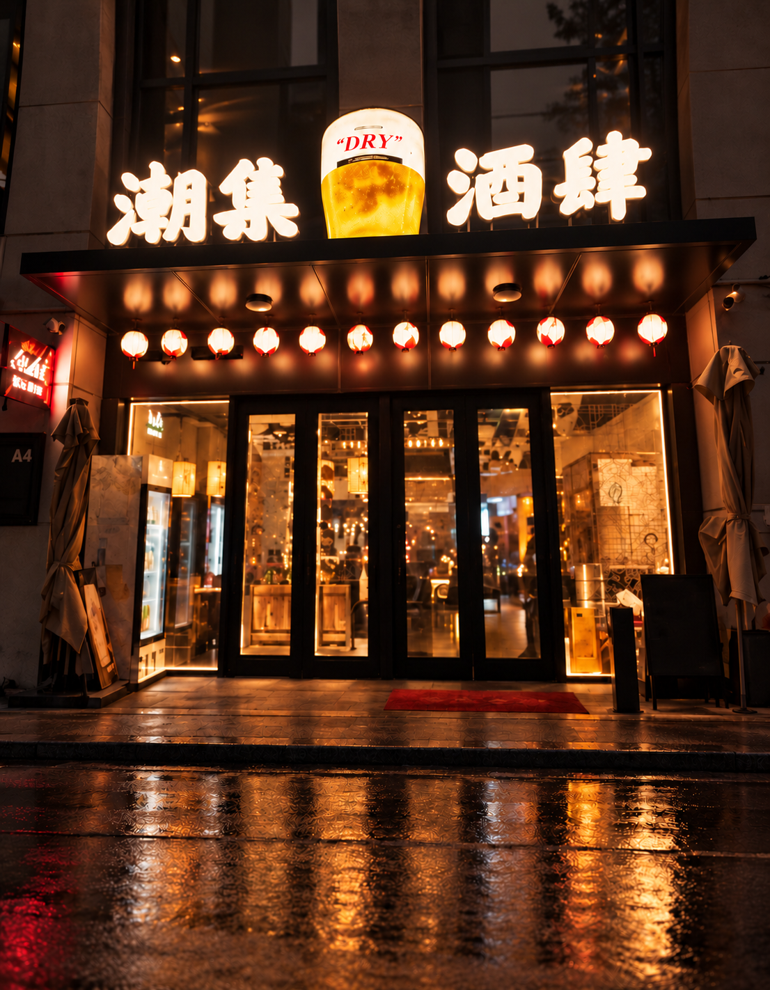 夜色中潮集炙酒肆的招牌与入口，暖色灯光映出店面